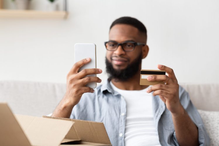 a guy holding a smartphone and a credit card