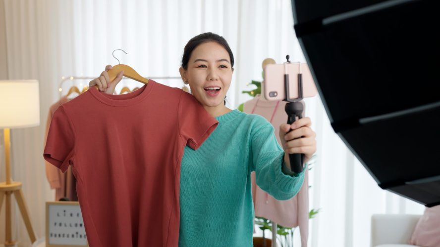 Asia vlogger woman influencer, SME retail store owner smile enjoy selling show live sale online screen in IG story reel tiktok work at home tailor studio. Gen Z people record video selfie shoot app.